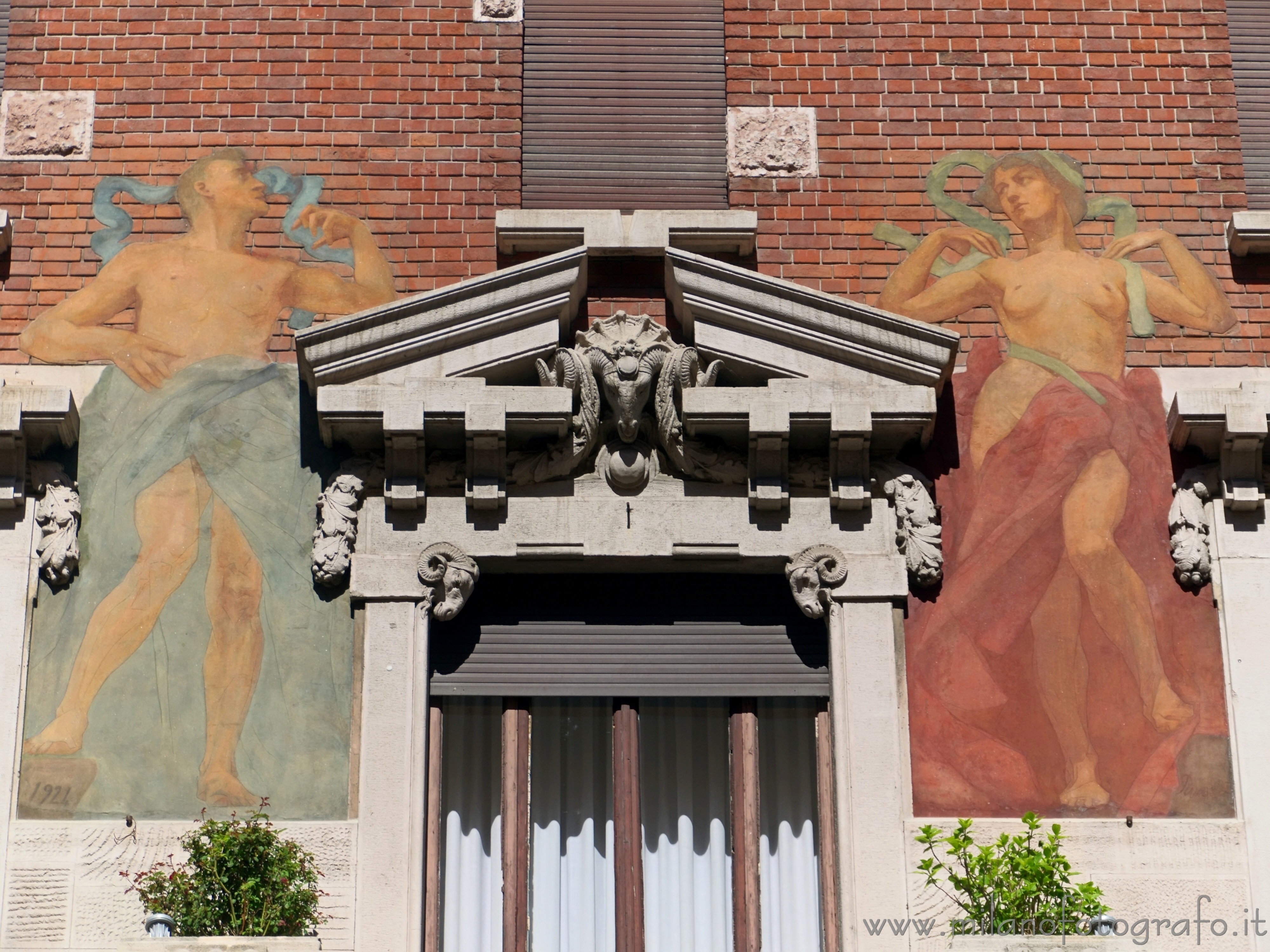 Milan (Italy) - The two persons painted on the facade of the Second House Berri Meregalli in the Quadrilateral of Silence